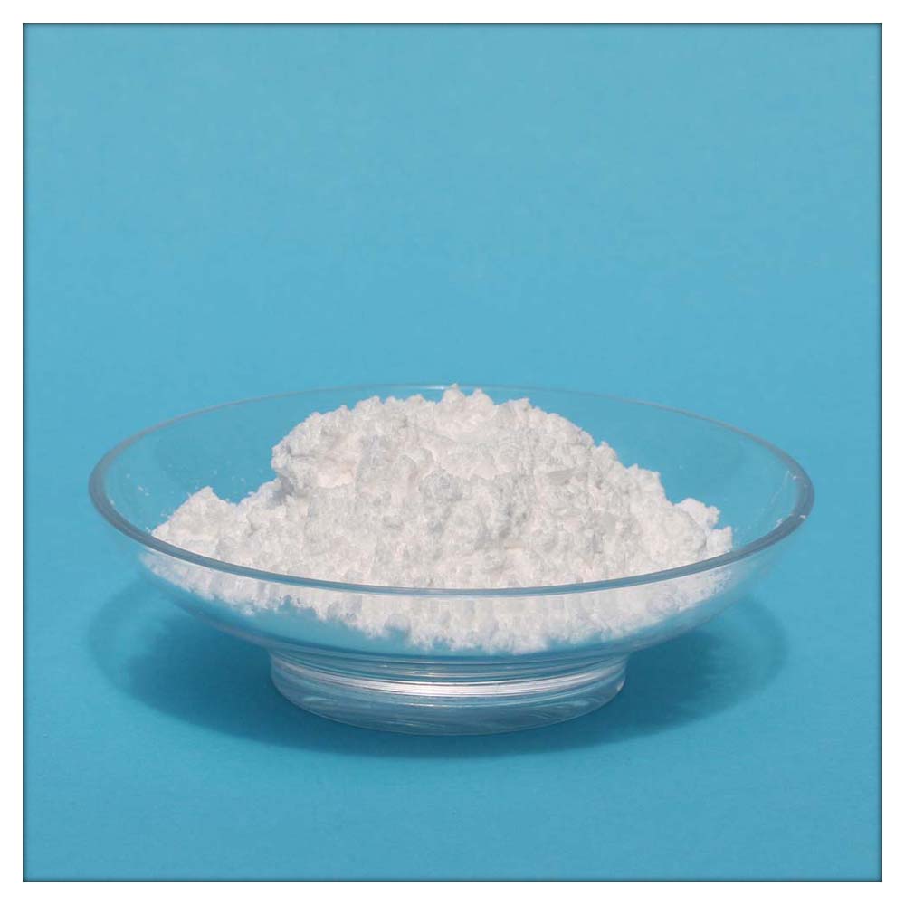 Ein Häufchen weißes Pulver (Aspartam) in einer Glasschale vor blauem Hintergrund.