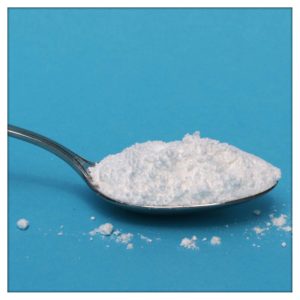 Birkenzucker (Xylit) ist gefährlich für Hunde. Das Bild zeigt einen Löffel mit gehäuftem weißen Pulver auf blauem Untergrund.